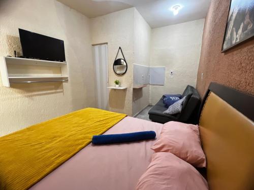 a bedroom with a large bed with a yellow blanket at Recanto Carioca Aconchegante in Rio de Janeiro