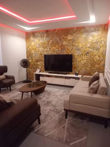 a living room with a flat screen tv on a stone wall at Woodloft in Lagos