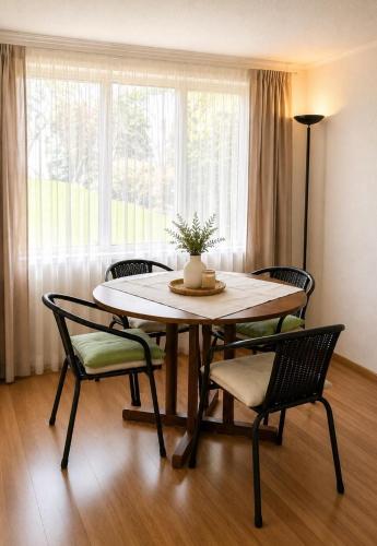 a table and chairs in a room with a window at Hostal y piezas individuales in Coihaique