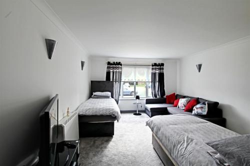 uma sala de estar com duas camas e um sofá em The Willows em Crawley