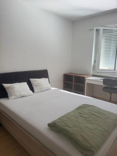 a bedroom with a bed with a green blanket on it at Basel Shared Apartment in Basel