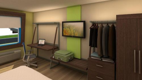 a room with a bed and a desk and a tv at Holiday Inn Express & Suites - Commerce by IHG in Commerce