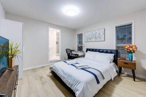 a bedroom with a large white bed and a desk at Bright Maple Suite in Richmond