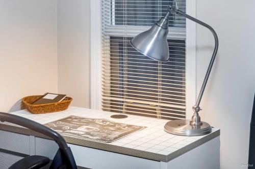 a desk with a lamp on top of a window at Bright Maple Suite in Richmond