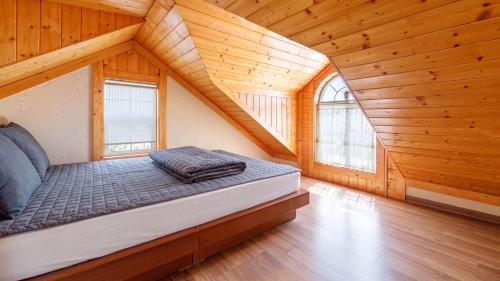 a bed in a room with wooden walls and windows at Ganghwa Western Beach Pension in Incheon