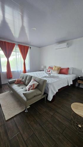 a bedroom with a large bed and a couch at Arenal Pecpen in Fortuna