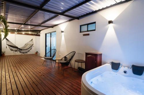a large room with a tub and a table and chairs at Arenal Pecpen in Fortuna