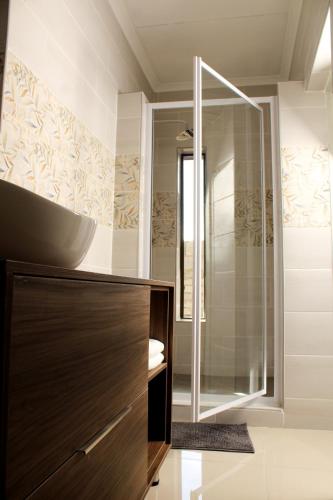 a bathroom with a sink and a glass shower at JUSTSAND Guesthouse in Virginia