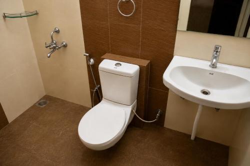 a bathroom with a toilet and a sink at Iyal Hotels and Resorts in Salem
