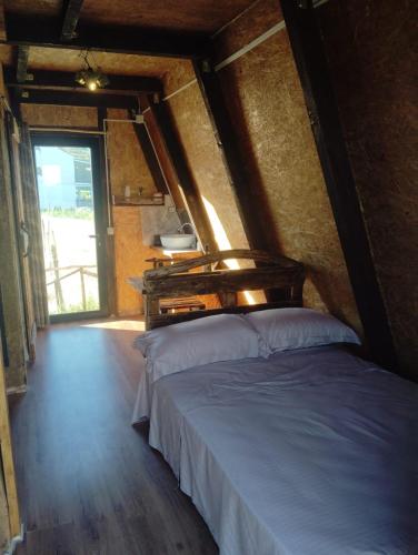 a bedroom with a bed in a room with a window at Cozy Lakefront Cabin - Myselim in Shkodër