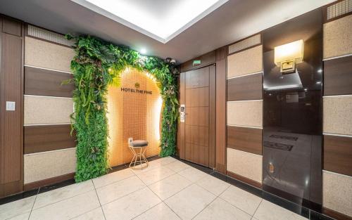 a hallway with a green plant on the wall at Hotel The Fine in Uijeongbu