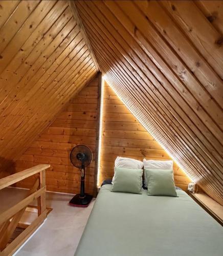 a room with a bed in a wooden attic at Le Chalet Spa Piscine in Rimbach-près-Masevaux