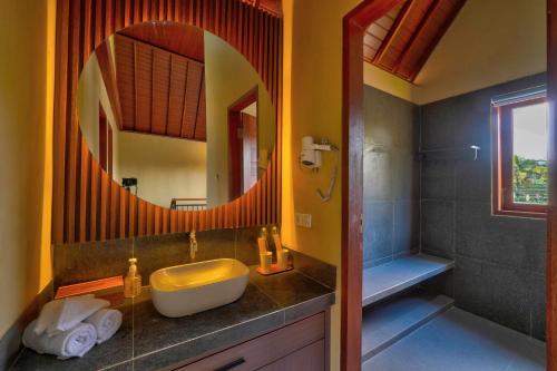 a bathroom with a sink and a mirror at Nandikara Villa in Payangan