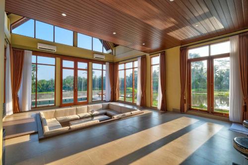a large living room with a couch and windows at Nandikara Villa in Payangan
