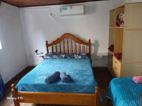 a bedroom with a bed with two pairs of shoes on it at Alojamiento UMA in Puerto Iguazú