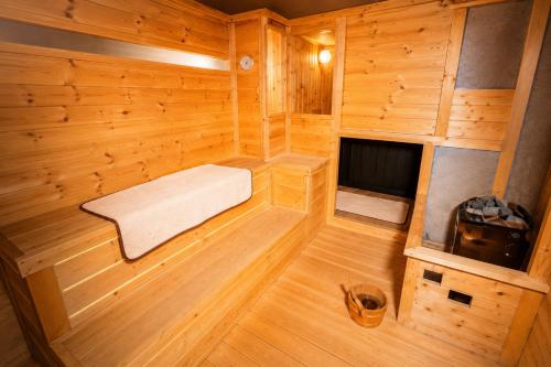 a small sauna with a bed and a tv at KAJAhause in Osaka