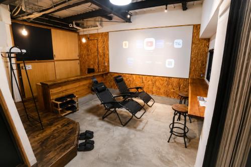 a meeting room with chairs and a projection screen at KAJAhause in Osaka