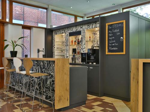 a bar in a restaurant with a black and white wall at ibis Berlin City Süd in Berlin