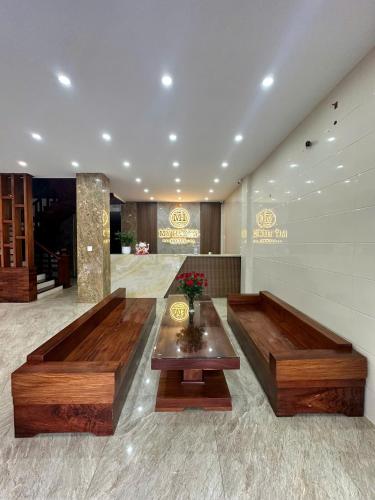 a lobby with two wooden benches in a building at Mỹ Hương Hotel in Quang Tri