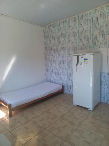a room with a bed and a refrigerator at Pousada Maia em Flor chale azul in Resende