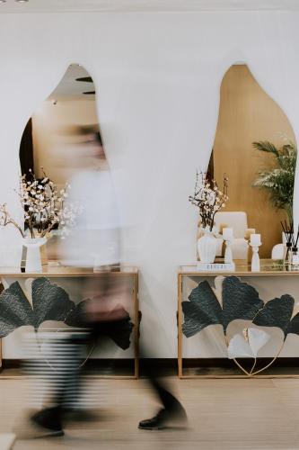 a person walking in front of a mirror in a room at Grand Duka Hotel & SPA in Durrës