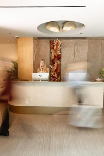 a woman sitting at a desk with a laptop at Grand Duka Hotel & SPA in Durrës