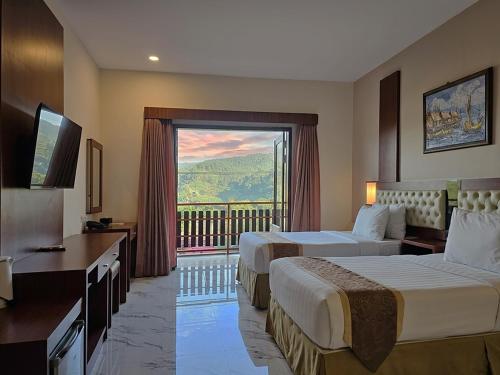 a hotel room with two beds and a large window at Spencer Green Hotel Batu in Punten