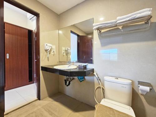 a bathroom with a sink and a toilet and a mirror at Spencer Green Hotel Batu in Punten