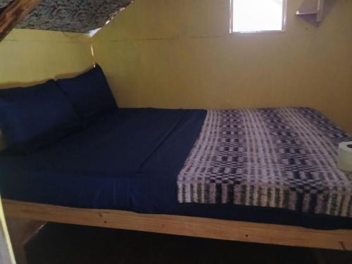 a bed in a small room with a window at Aldea Axocobaca in Zoquitlán