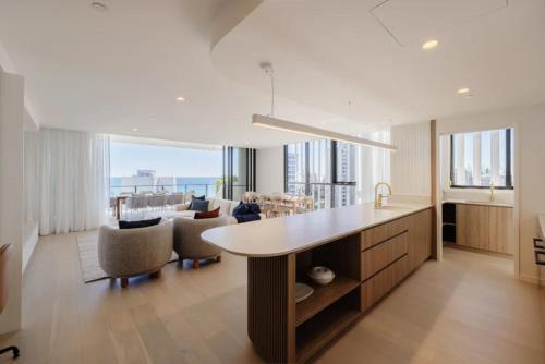 a kitchen and living room with a table and chairs at Esprit Holidays Rainbow Bay in Gold Coast