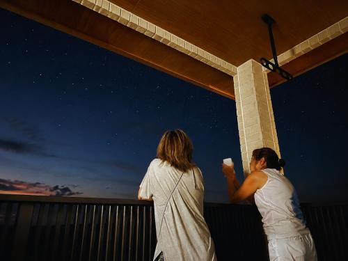 two women standing on a balcony looking at the stars at Wight Turtle Villa -Ishigaki Blue Retreat in Ishigaki Island