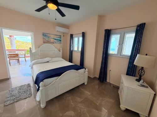 a bedroom with a white bed and a ceiling fan at Sea-Renity in Philipsburg