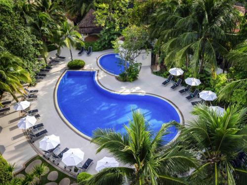 an overhead view of a pool with chairs and umbrellas at Ibis Phuket Patong in Patong Beach