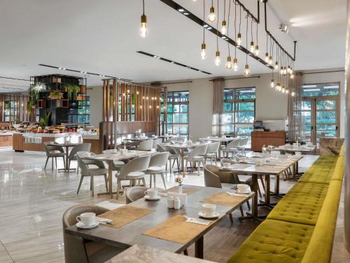 a restaurant with tables and chairs and a cafeteria at Novotel Trabzon in Trabzon