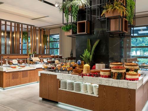 a restaurant with a buffet of food on a counter at Novotel Trabzon in Trabzon