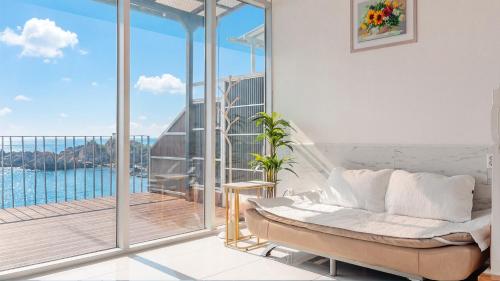 a living room with a couch and a balcony at Yeongdeok Searest Poolvilla in Yŏngdŏk
