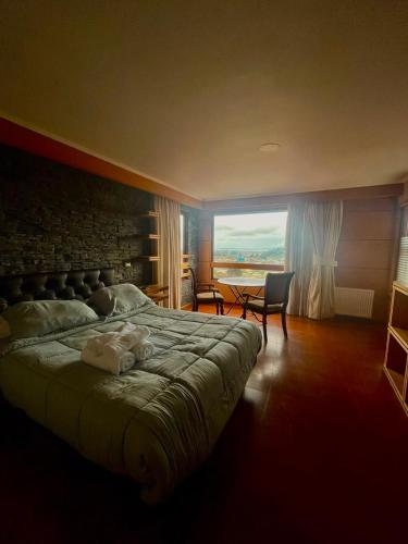 a bedroom with a large bed and a large window at Hotel Peregrino Suites in Concepción