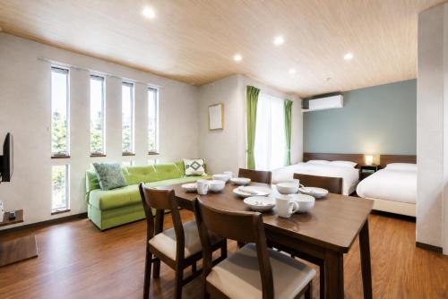 a room with a dining table and a bedroom at ミニョン マッペ in Osaka