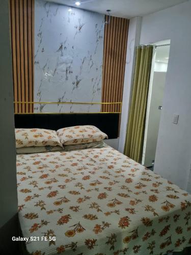 a bedroom with a bed with a comforter on it at Barrinha Beach flats in Saquarema