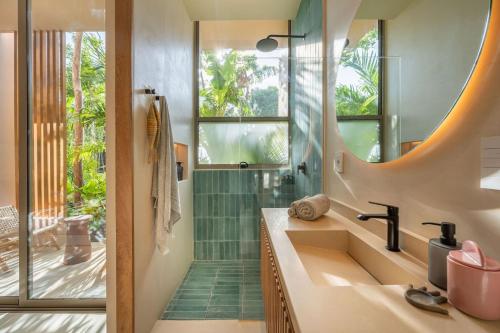 a bathroom with a sink and a shower with a mirror at Amazing 1BR Tulum Jungle with Restaurant, Pool and Gym in Tulum