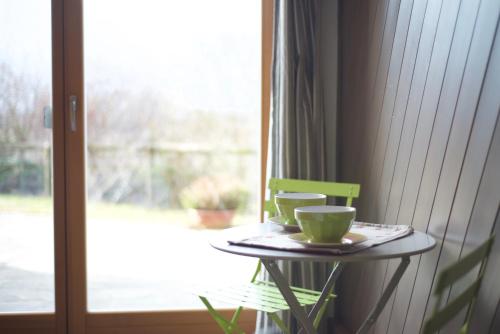 a table with two cups on it next to a window at A&B Le Terrazze del Sale' - Apartments in Trento