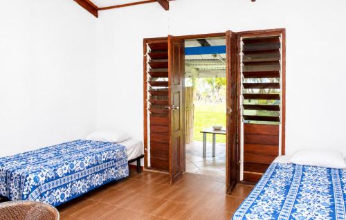 a room with two beds and a glass door at Bluepango Guest House in Port Vila