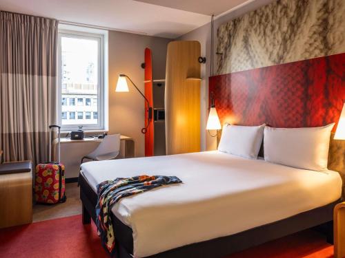 a hotel room with a large bed and a window at ibis Rotterdam City Centre in Rotterdam