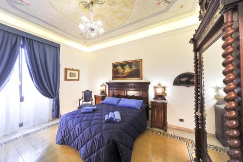 um quarto com uma cama com lençóis azuis e um tecto em Central Domus Roma em Roma