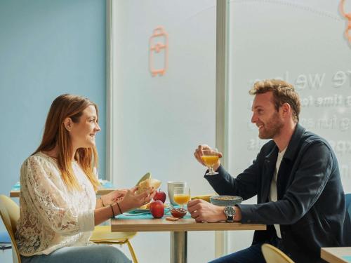 a man and woman sitting at a table drinking wine at Aparthotel Adagio Access Nice Magnan in Nice