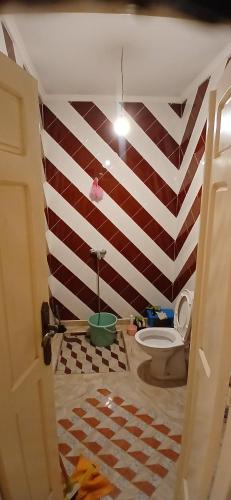 a bathroom with a red and white striped wall at mirleft in Mirleft