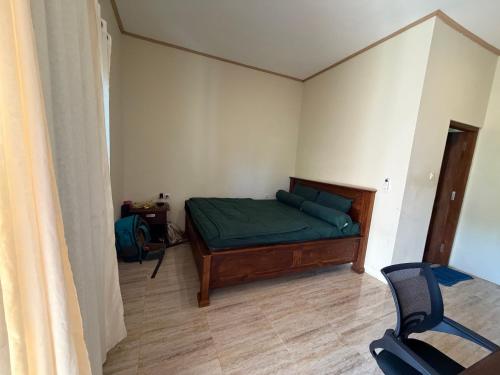 a bedroom with a bed and a chair in it at Mamat warung bed & breakfast in Huu