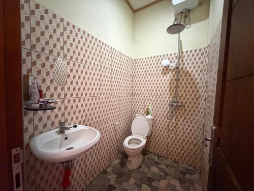 a small bathroom with a sink and a toilet at Mamat warung bed & breakfast in Huu