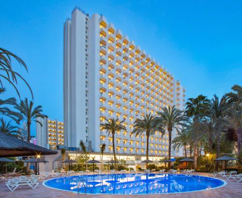 a hotel with a pool in front of a building at SOL by Meliá Pelícanos Ocas in Benidorm