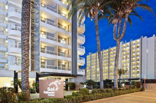 a hotel with palm trees in front of it at SOL by Meliá Pelícanos Ocas in Benidorm